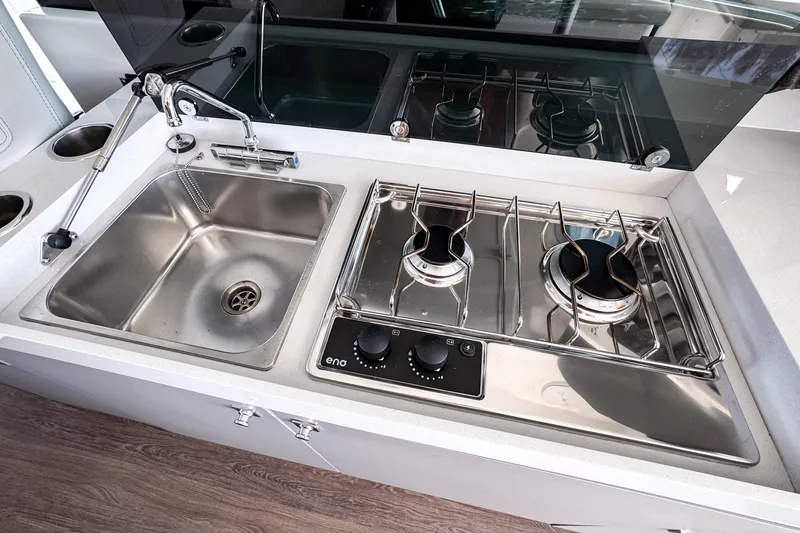 Slide: The Image of Modern kitchen area on 2023 Beneteau Antares 11 with sink and dual-burner stove. - 19