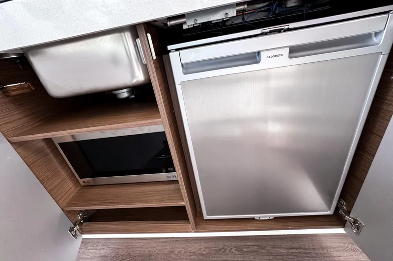 Slide: The Image of Modern kitchen area in 2023 Beneteau Antares 11 with sink, microwave, and Dometic fridge. - 21