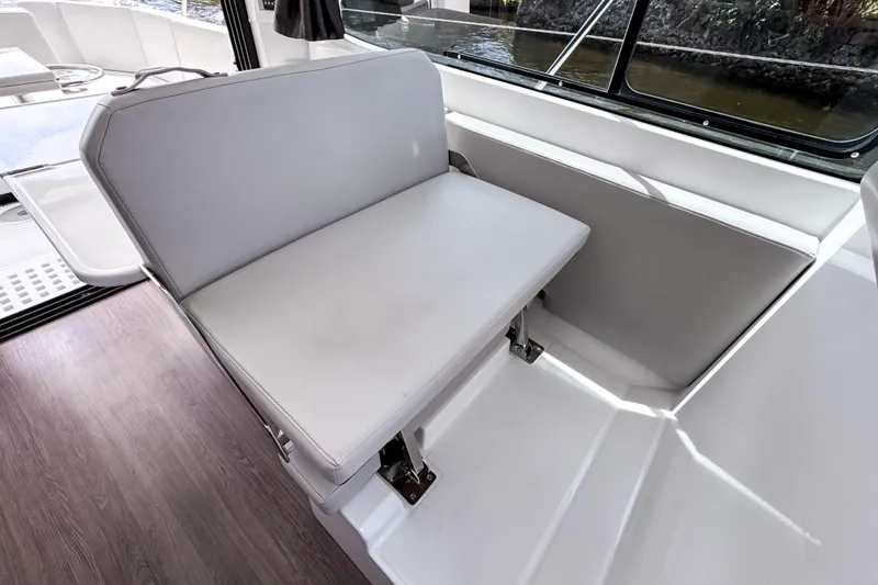 Slide: The Image of Interior seating of 2023 Beneteau Antares 11 boat, featuring sleek white upholstery. - 24
