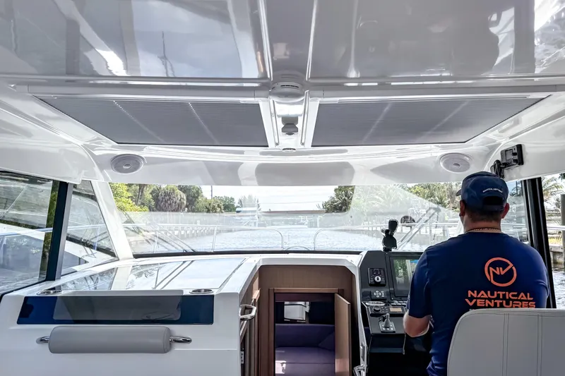 Slide: The Image of Interior view of 2023 Beneteau Antares 11 boat with captain navigating. - 25