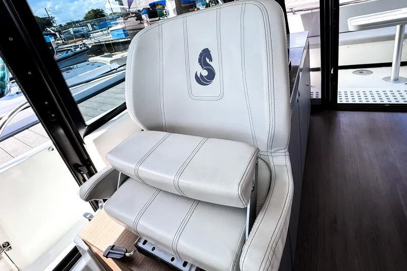 Slide: The Image of Captain's chair on 2023 Beneteau Antares 11 boat, featuring a seahorse emblem. - 29