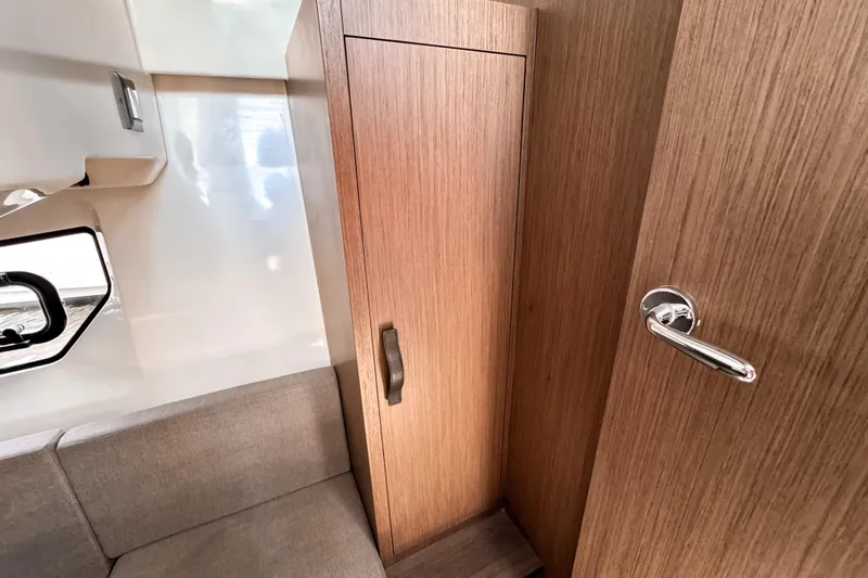 Slide: The Image of Interior of 2023 Beneteau Antares 11, featuring wooden cabinetry and a cozy seating area. - 42