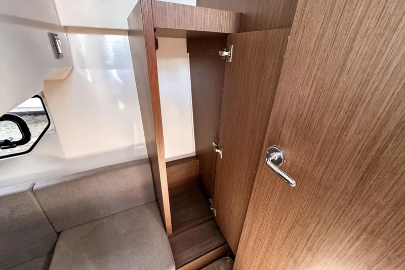 Slide: The Image of 2023 Beneteau Antares 11 interior with open wooden cabinet and seating area. - 43