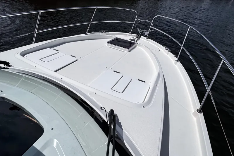 Slide: The Image of 2023 Beneteau Antares 11 boat deck with sleek design and railing, on calm water. - 44