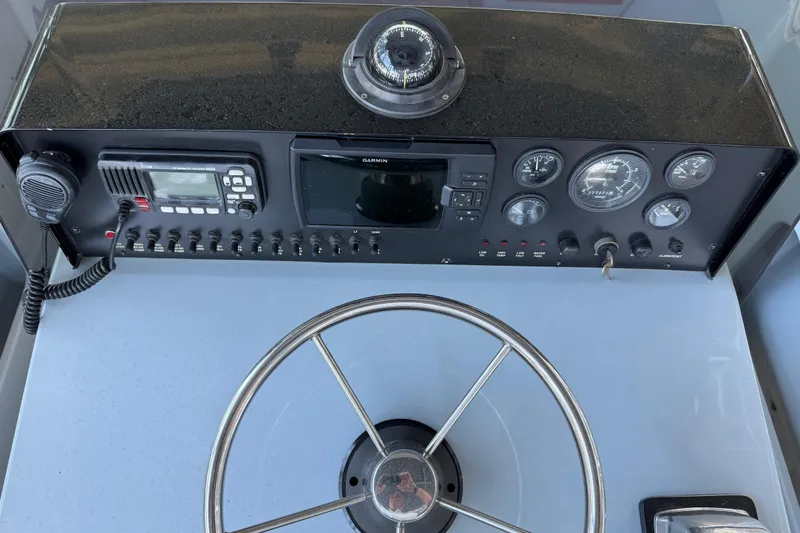 Slide: The Image of 2024 Strike 26 Center Console Cuddy dashboard with steering wheel and navigation instruments. - 10