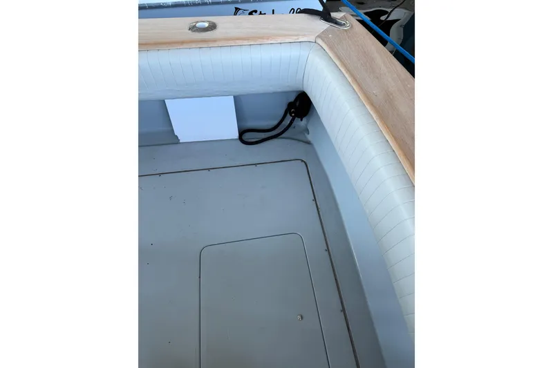 Slide: The Image of 2024 Strike 26 Center Console Cuddy boat interior with cushioned seating and storage compartment. - 24