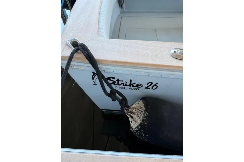 Slide: The Image of 2024 Strike 26 Center Console Cuddy boat with fender and rope detail. - 26