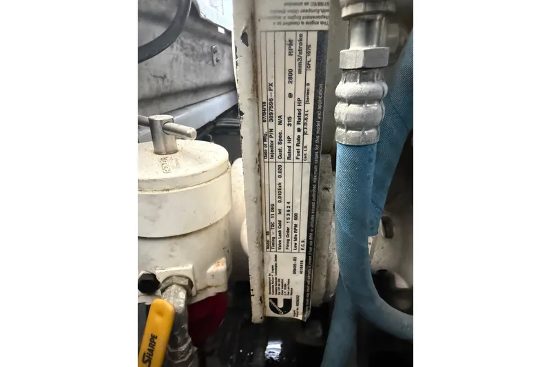 Slide: The Image of Engine compartment of 2024 Strike 26 Center Console Cuddy with visible labels and hoses. - 5