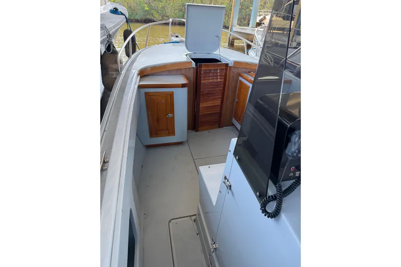 Slide: The Image of 2024 Strike 26 Center Console Cuddy boat interior with wooden cabinetry and open hatch. - 8