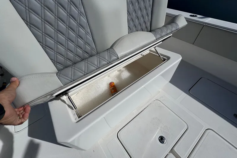 Slide: The Image of 2021 Invincible 36 Open Fisherman boat seat storage compartment open, revealing interior space. - 7