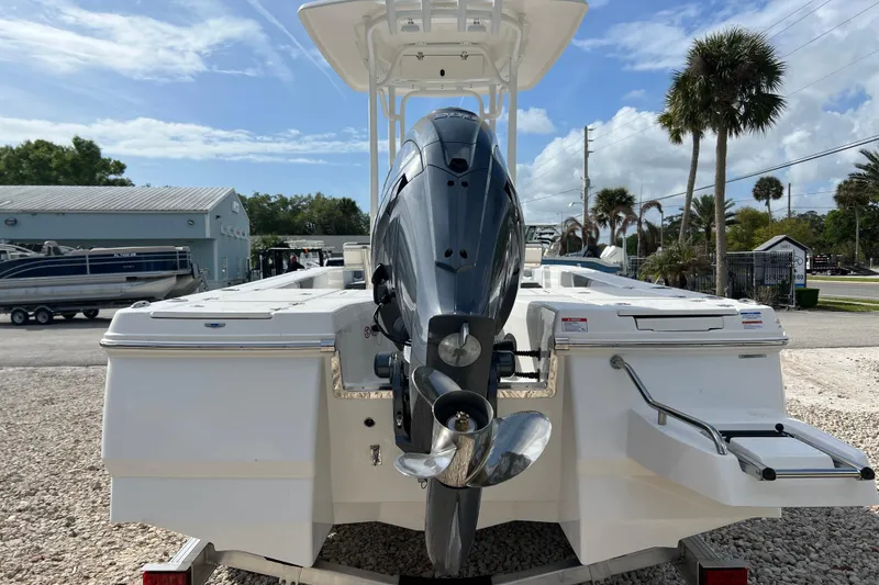 Slide: The Image of 2026 Robalo 226 Cayman boat with outboard motor, parked outdoors under a clear sky. - 3