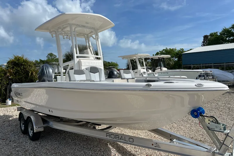 Slide: The Image of 2026 Robalo 226 Cayman boat on trailer under clear blue sky. - 6