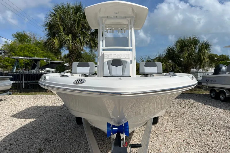 Slide: The Image of 2026 Robalo 226 Cayman boat on trailer, surrounded by palm trees and clear sky. - 7