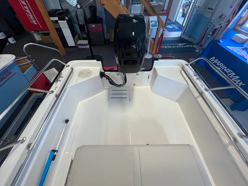 Slide: The Image of Interior view of a Boston Whaler 150 Montauk with a clean, white deck and outboard motor. - 3