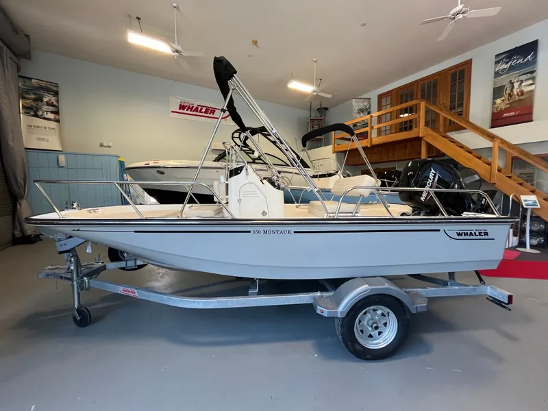 Slide: The Image of Boston Whaler 150 Montauk 2026 on a trailer in a showroom. - 0