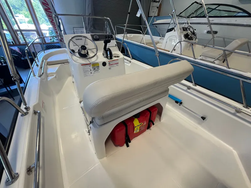 Slide: The Image of The image shows the cockpit of a Boston Whaler 150 Montauk with a helm and seating. - 4