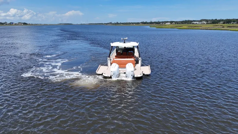 Slide: The Image of Saxdor 320 GTO 2027 on calm water with dual outboard engines. - 34