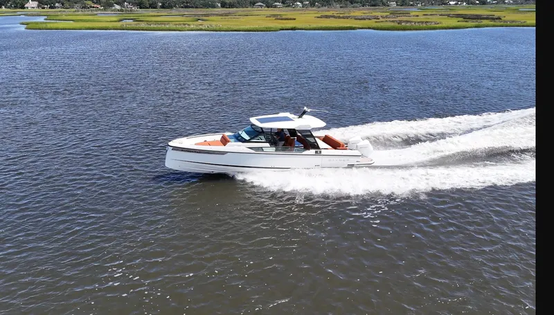 Slide: The Image of A 2027 Saxdor 320 GTO speeds across the water in a tranquil setting. - 30
