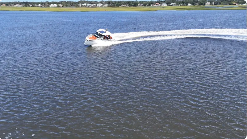Slide: The Image of A 2027 Saxdor 320 GTO speeds across the water, with a shoreline in the background. - 31