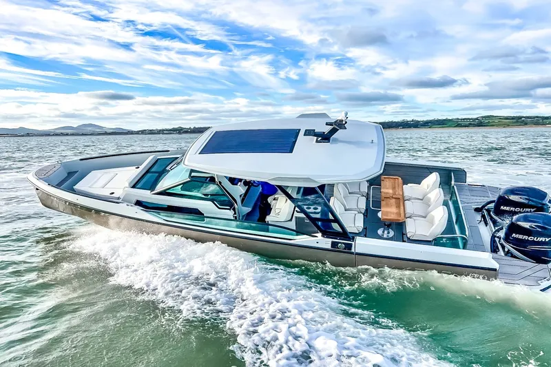 Slide: The Image of The image shows a modern Saxdor 320 GTO boat from 2027 on the water. It features a sleek design with a spacious deck and two Mercury engines. - 28