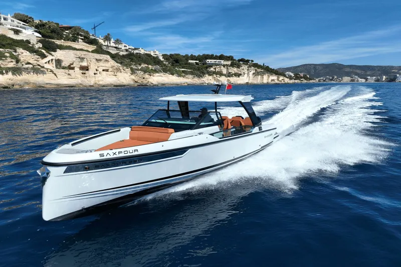 Slide: The Image of A 2027 Saxdor 320 GTO speeds across blue water, surrounded by rocky cliffs. - 35