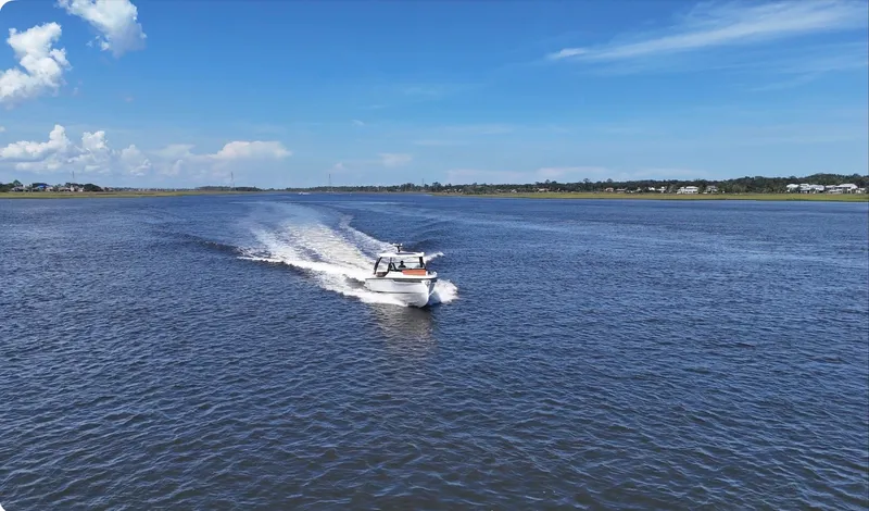 Slide: The Image of A 2027 Saxdor 320 GTO speeds across the water under a clear blue sky. - 45