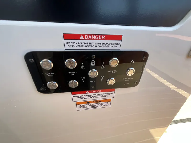 Slide: The Image of Control panel with buttons and warning labels on a boat. - 24