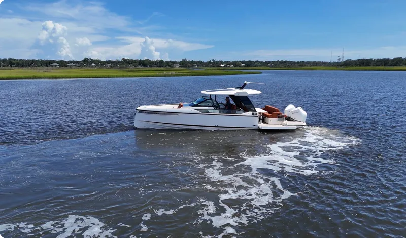Slide: The Image of A 2027 Saxdor 320 GTO cruising on calm waters under a partly cloudy sky. - 0