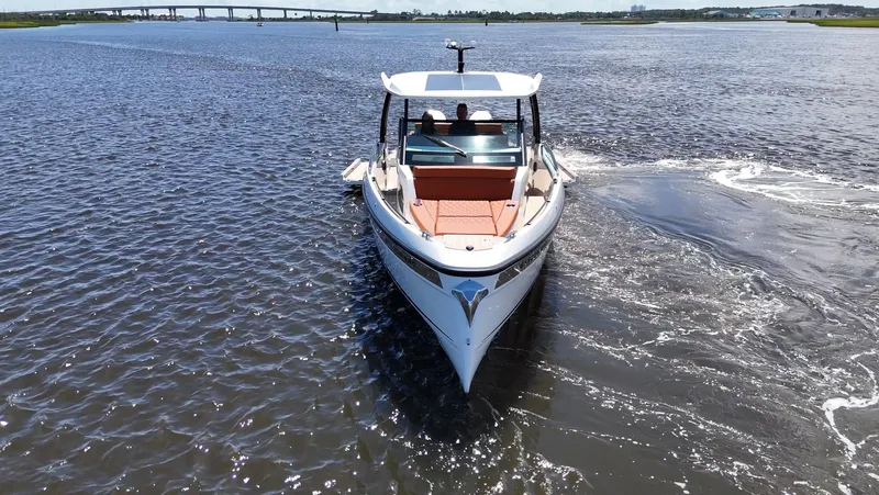 Slide: The Image of A 2027 Saxdor 320 GTO cruising on calm waters with a bridge in the background. - 35