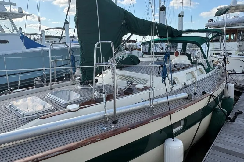 Slide: The Image of Sailboat Norseman 447, 1981 model, docked with green covers and wooden deck. - 11