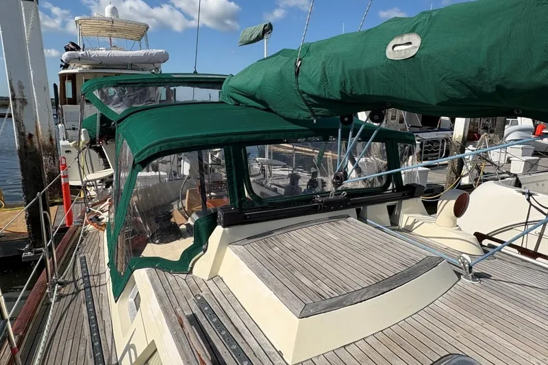 Slide: The Image of 1981 Norseman 447 sailboat with green canopy docked at marina. - 12