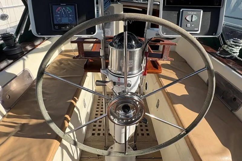 Slide: The Image of Steering wheel of a 1981 Norseman 447 sailboat, featuring navigation instruments. - 16