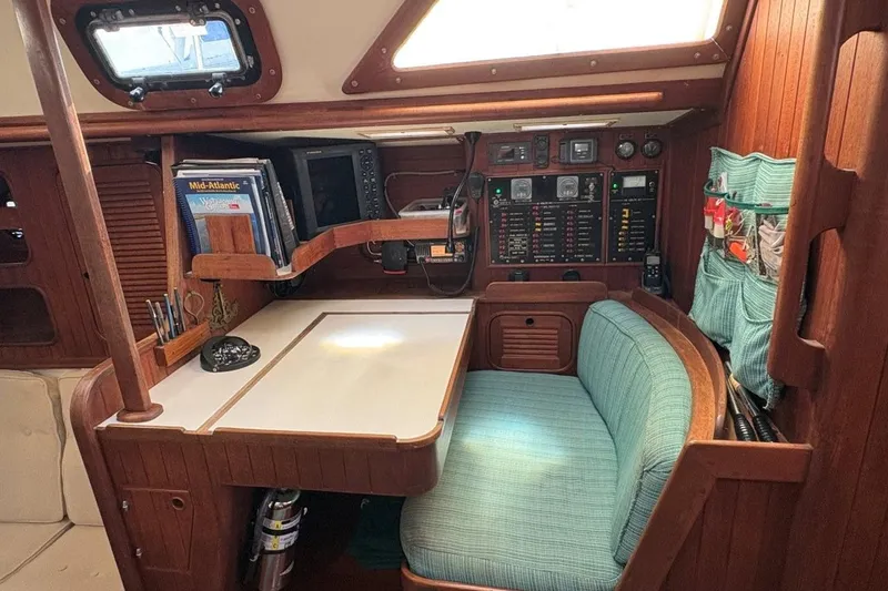 Slide: The Image of Cozy navigation station in 1981 Norseman 447 sailboat with wood paneling and teal seating. - 22