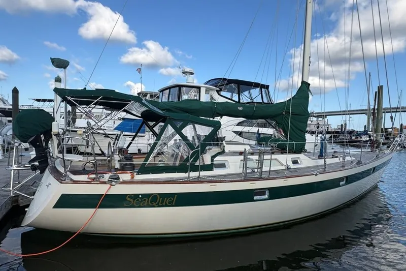 Slide: The Image of Sailboat "SeaQuel" docked, 1981 Norseman 447 model, green and white design, clear sky background. - 3