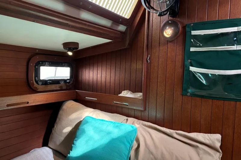 Slide: The Image of Cozy cabin interior of 1981 Norseman 447 sailboat with wood paneling and teal accents. - 34