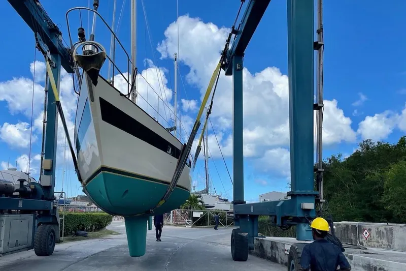 Slide: The Image of Norseman 447 sailboat from 1981 being lifted by a crane at a marina. - 43
