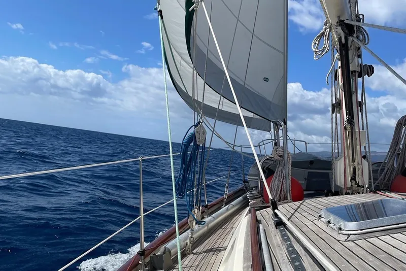 Slide: The Image of Sailing on a 1981 Norseman 447 yacht, open sea, clear skies, and billowing sails. - 7