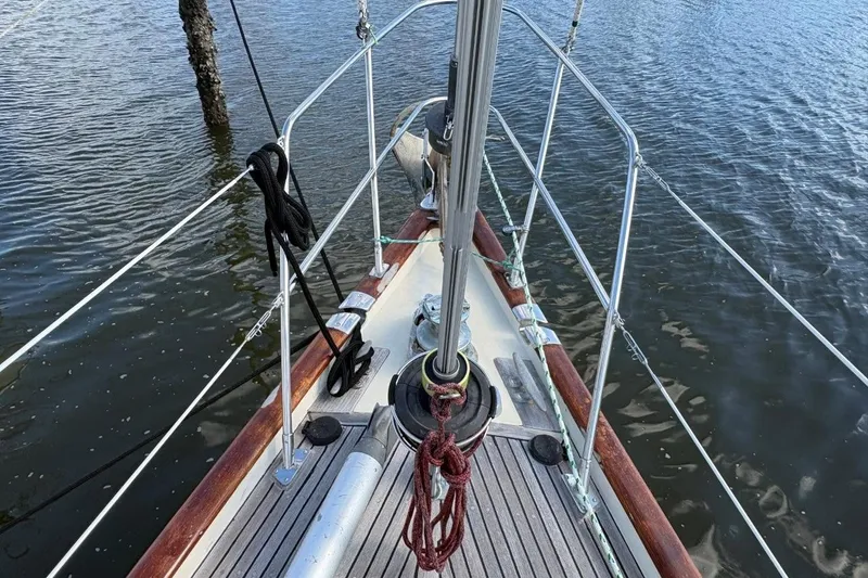 Slide: The Image of Bow of 1981 Norseman 447 sailboat with ropes and railing on calm water. - 9