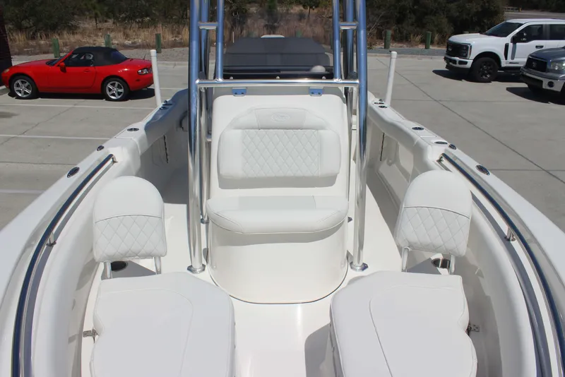 Slide: The Image of 2026 Key West 203 FS boat interior with white seating, parked cars in the background. - 19