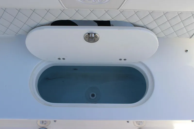 Slide: The Image of Livewell compartment on a 2026 Key West 203 FS boat, featuring a white lid and quilted upholstery. - 25