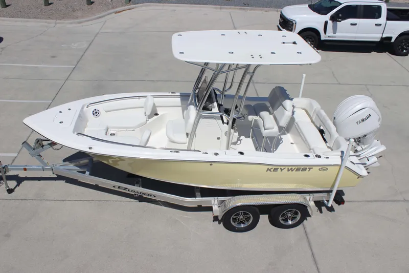 Slide: The Image of 2026 Key West 203 FS boat on trailer, featuring Yamaha engine, parked in lot. - 31