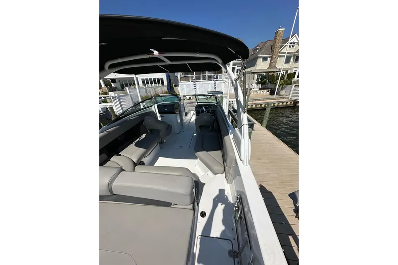 Slide: The Image of 2022 Four Winns HD8 OB boat docked, showcasing spacious seating and sleek design. - 19