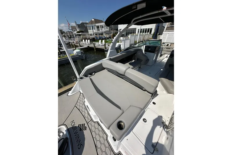Slide: The Image of 2022 Four Winns HD8 OB boat with spacious seating, docked at a marina. - 20