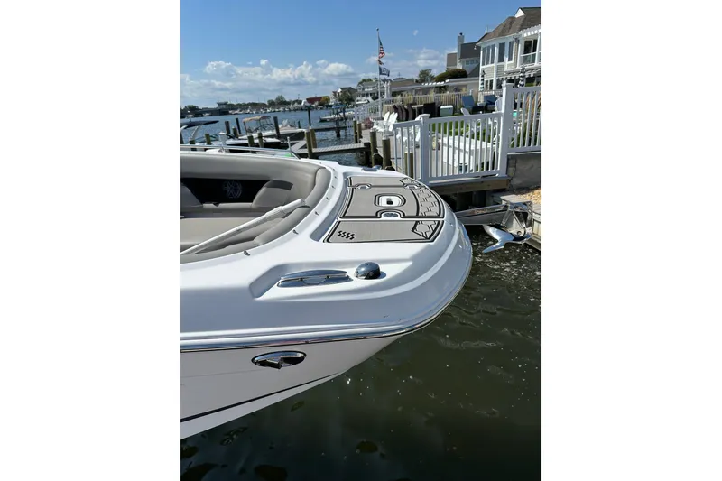 Slide: The Image of 2022 Four Winns HD8 OB boat docked by waterfront homes. - 23