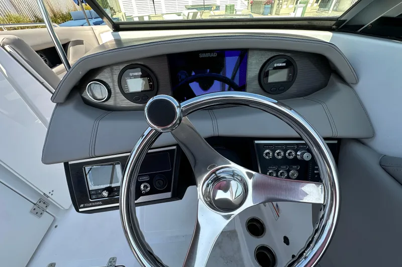 Slide: The Image of 2022 Four Winns HD8 OB boat dashboard with steering wheel and control panels. - 7