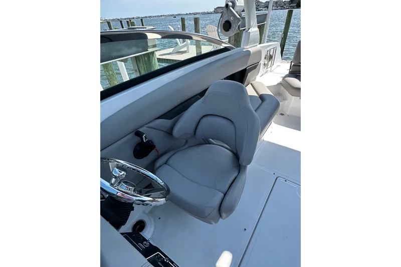 Slide: The Image of 2022 Four Winns HD8 OB boat interior with gray captain's seat and steering wheel. - 8