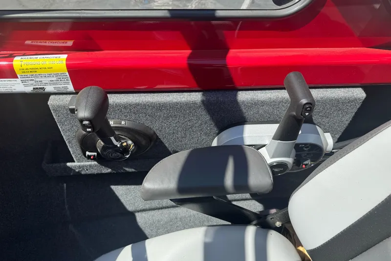 Slide: The Image of Interior controls of a 2026 Lund 210 Heavy Gauge boat, featuring dual levers and seating. - 19