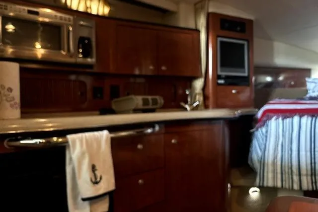 Slide: The Image of Interior of 2006 Sea Ray Sundancer 320 yacht with kitchen and cozy sleeping area. - 25