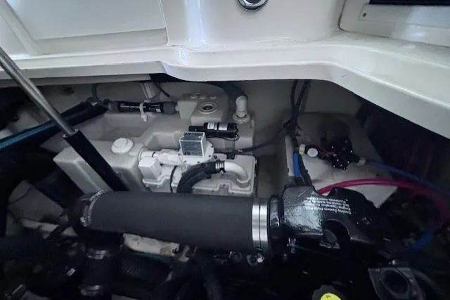 Slide: The Image of Engine compartment of a 2006 Sea Ray Sundancer 320, showcasing mechanical components and hoses. - 43