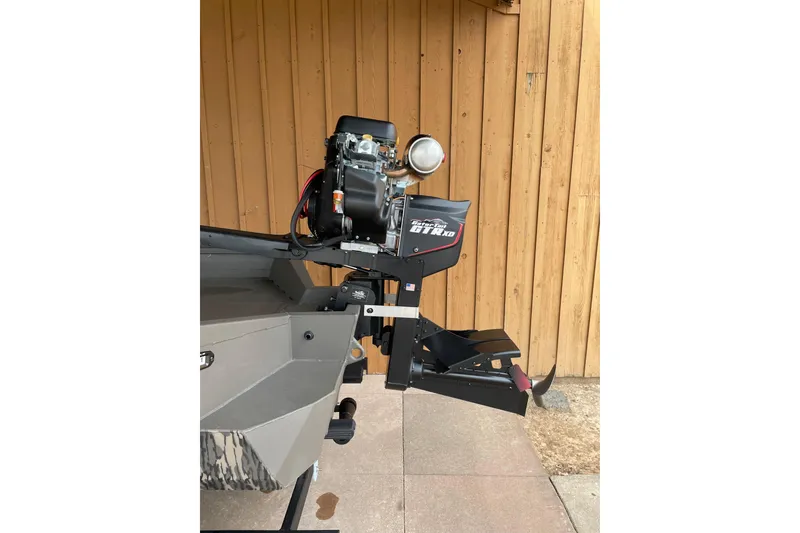 Slide: The Image of 2026 Reaper Boats 653 Timber Reaper with powerful outboard motor, wooden backdrop. - 7